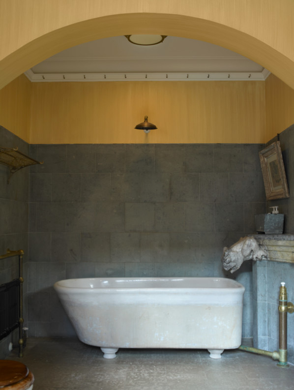 Ispirazione per una grande stanza da bagno padronale tradizionale con vasca/doccia, WC a due pezzi, piastrelle grigie, piastrelle in pietra e pareti gialle