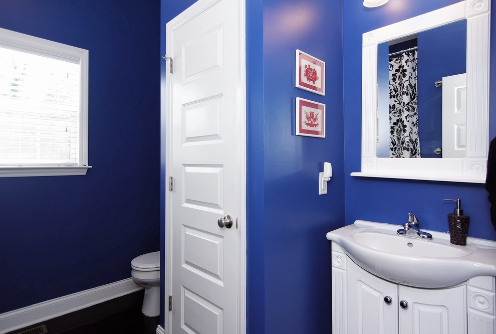 Kleines Modernes Duschbad mit verzierten Schränken, weißen Schränken, Eckbadewanne, Duschbadewanne, Toilette mit Aufsatzspülkasten, blauen Fliesen, Keramikfliesen, blauer Wandfarbe, dunklem Holzboden, Waschtischkonsole, Glaswaschbecken/Glaswaschtisch, weißer Waschtischplatte, Einzelwaschbecken, freistehendem Waschtisch, braunem Boden und Duschvorhang-Duschabtrennung in Raleigh