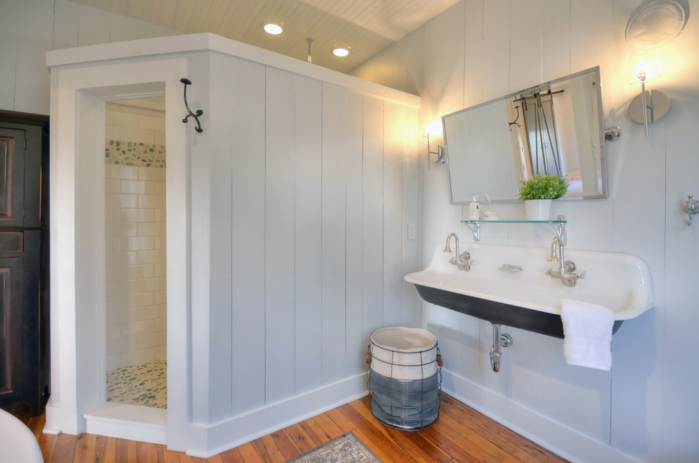 Aménagement d'une salle de bain campagne avec une douche d'angle, un mur gris, un sol en bois brun et une grande vasque.