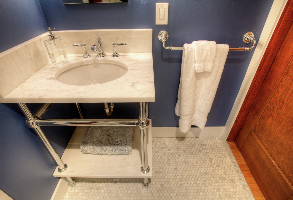 Amerikansk inredning av ett litet badrum, med möbel-liknande, en öppen dusch, en toalettstol med separat cisternkåpa, vit kakel, tunnelbanekakel, blå väggar, marmorgolv, ett konsol handfat och marmorbänkskiva