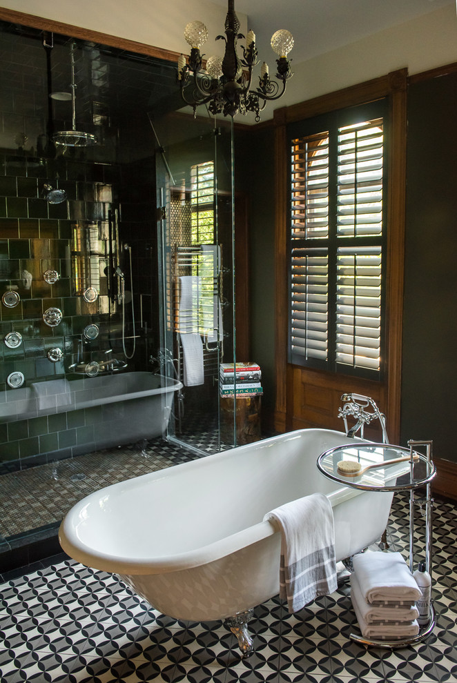 Inredning av ett klassiskt stort svart svart en-suite badrum, med ett badkar med tassar, en öppen dusch, en toalettstol med hel cisternkåpa, grön kakel, keramikplattor, gröna väggar, cementgolv, ett konsol handfat, granitbänkskiva, flerfärgat golv och dusch med gångjärnsdörr
