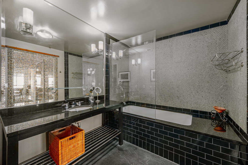 Exempel på ett mellanstort industriellt svart svart en-suite badrum, med öppna hyllor, svarta skåp, ett undermonterat badkar, en dusch/badkar-kombination, grå kakel, betonggolv, ett undermonterad handfat, med dusch som är öppen, mosaik och grått golv
