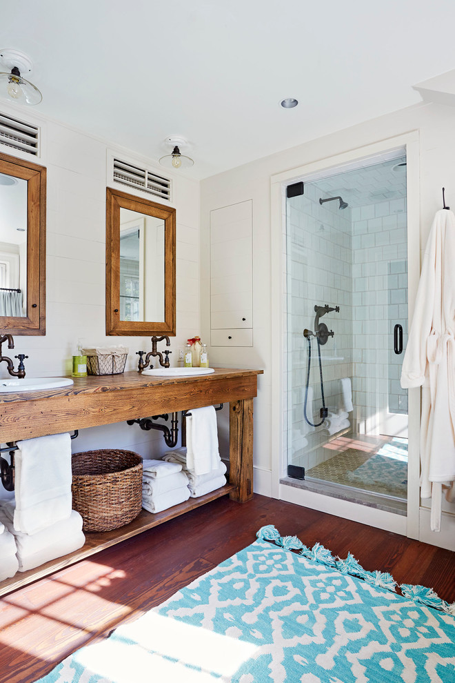 Foto di una stanza da bagno padronale country con pareti bianche, parquet scuro, lavabo da incasso, top in legno e porta doccia a battente