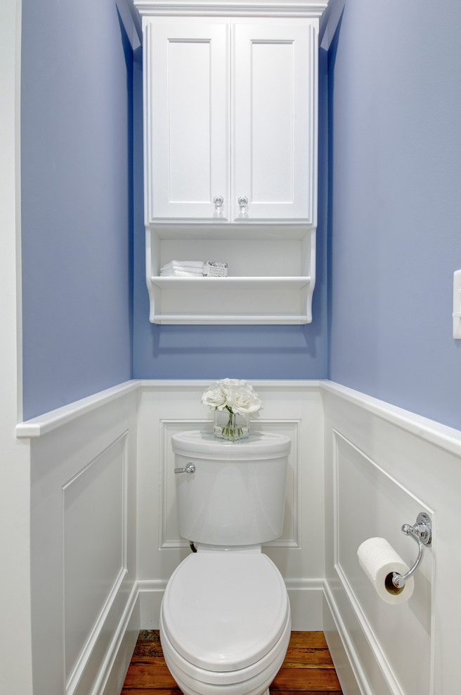 Inredning av ett klassiskt litet badrum med dusch, med luckor med infälld panel, vita skåp, en hörndusch, en toalettstol med hel cisternkåpa, vit kakel, keramikplattor, lila väggar, mellanmörkt trägolv, ett undermonterad handfat, bänkskiva i kvartsit och dusch med gångjärnsdörr