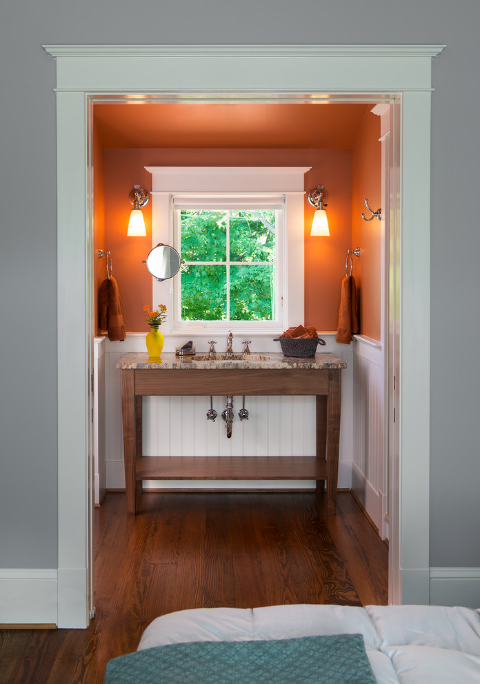 Modelo de cuarto de baño ecléctico pequeño con parades naranjas, suelo de madera oscura, aseo y ducha, lavabo bajoencimera y encimera de granito
