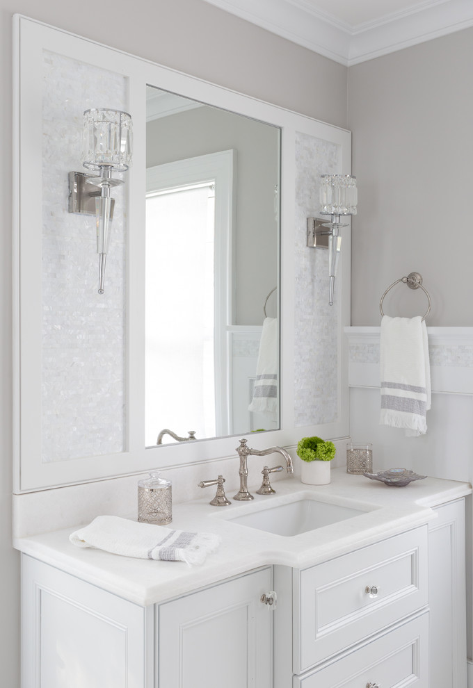 На фото: большая главная ванная комната в морском стиле с фасадами островного типа, белыми фасадами, отдельно стоящей ванной, душем в нише, унитазом-моноблоком, белой плиткой, мраморной плиткой, серыми стенами, мраморным полом, накладной раковиной, мраморной столешницей, белым полом, душем с распашными дверями и белой столешницей
