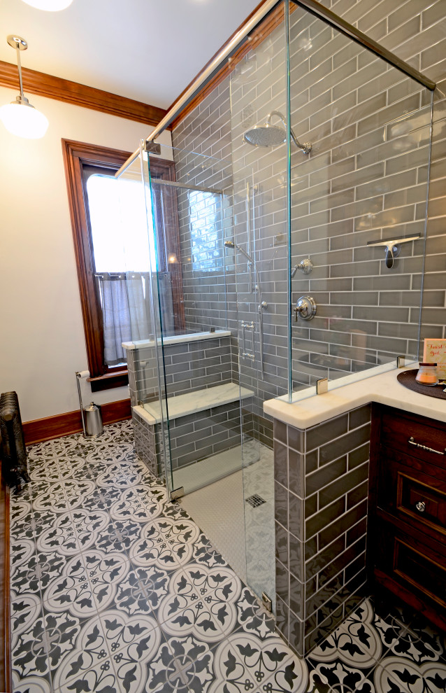 Inspiration for a large victorian ensuite bathroom in Milwaukee with beaded cabinets, medium wood cabinets, a built-in shower, a two-piece toilet, grey tiles, porcelain tiles, porcelain flooring, a built-in sink, granite worktops, a hinged door, white worktops, a shower bench, a single sink and a built in vanity unit.