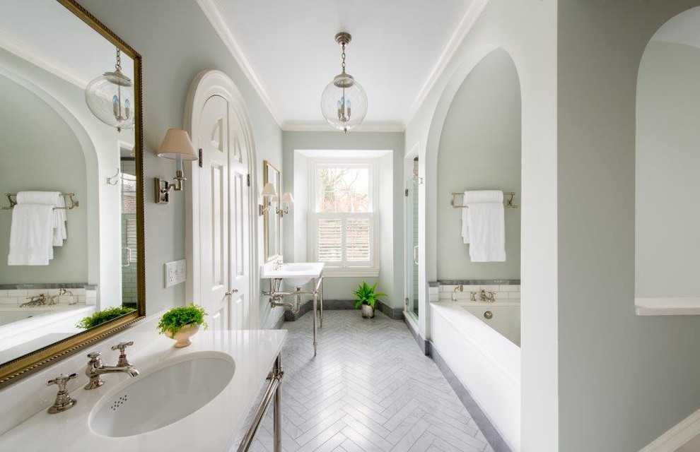 Elegant white tile and stone tile alcove shower photo in DC Metro with a console sink, blue walls and an undermount tub