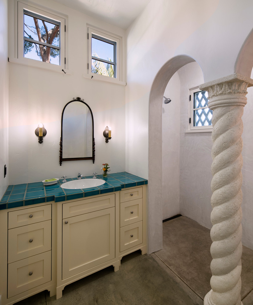Пример оригинального дизайна: маленькая ванная комната в средиземноморском стиле с фасадами с утопленной филенкой, бежевыми фасадами, синей плиткой, керамогранитной плиткой, белыми стенами, бетонным полом, накладной раковиной и столешницей из плитки для на участке и в саду