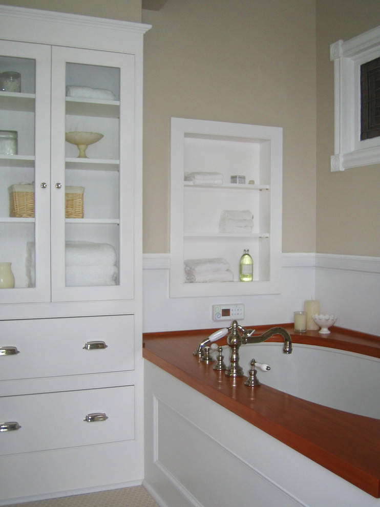 Example of a mid-sized classic master beige tile and ceramic tile ceramic tile double shower design in Burlington with a console sink, furniture-like cabinets, white cabinets, wood countertops, an undermount tub, a two-piece toilet and beige walls