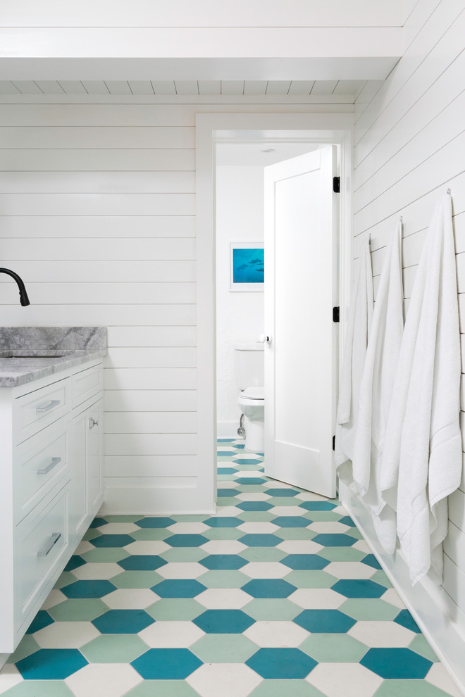 Réalisation d'une salle d'eau tradition avec un placard à porte shaker, des portes de placard blanches, WC séparés, un mur blanc, un lavabo encastré et un sol bleu.