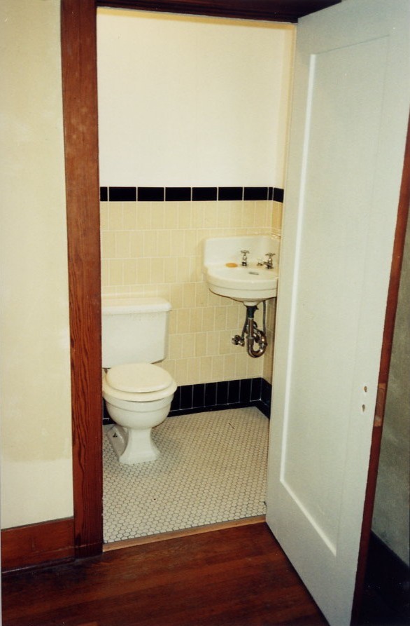 Exemple d'une petite salle d'eau chic avec une douche d'angle, WC séparés, un carrelage beige, un carrelage noir, un carrelage blanc, mosaïque, un mur beige, un sol en carrelage de terre cuite et un lavabo suspendu.