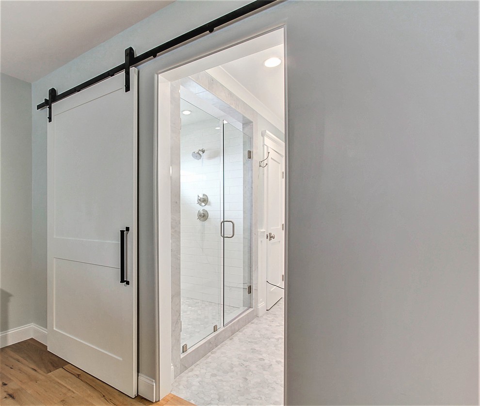 Идея дизайна: большая главная ванная комната в классическом стиле с фасадами в стиле шейкер, белыми фасадами, двойным душем, белой плиткой, плиткой кабанчик, серыми стенами, мраморным полом, врезной раковиной и столешницей из гранита