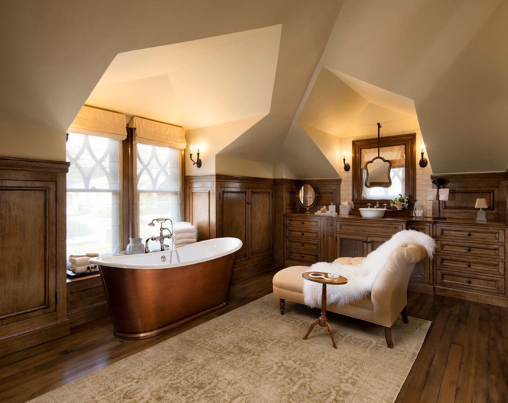Idéer för att renovera ett medelhavsstil badrum, med luckor med infälld panel, skåp i mörkt trä, ett fristående badkar, beige väggar, mörkt trägolv, ett fristående handfat och brunt golv