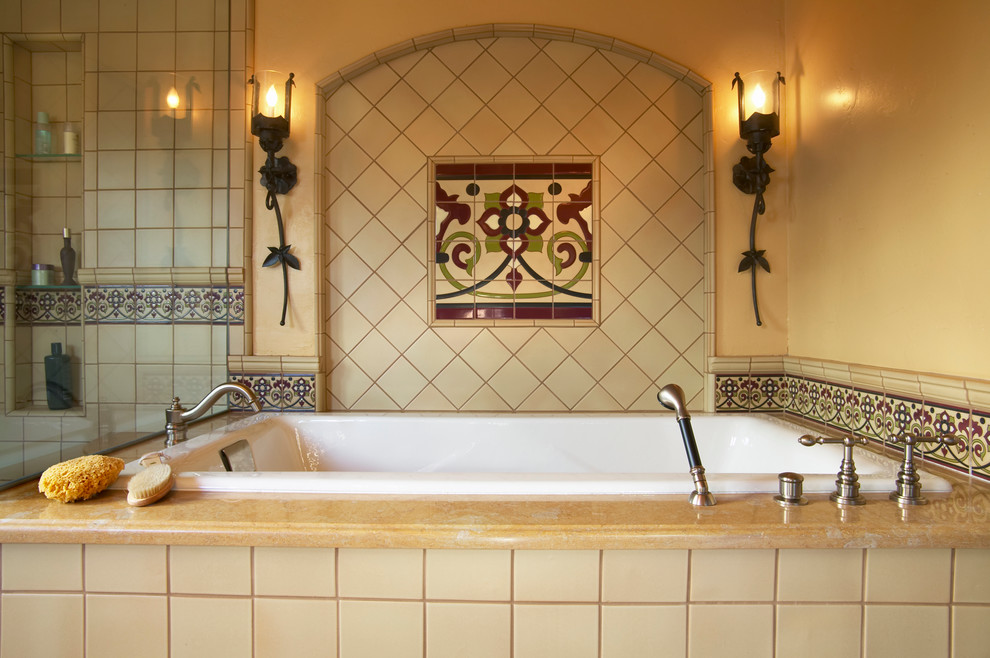 Ispirazione per una stanza da bagno mediterranea con vasca da incasso, piastrelle multicolore, piastrelle in ceramica e pareti gialle