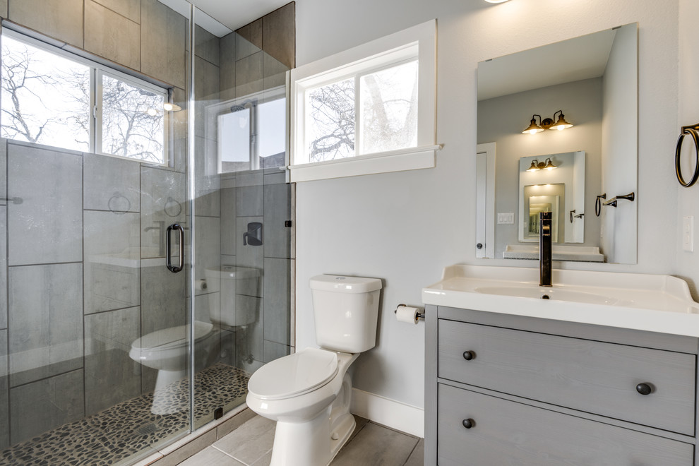 Inspiration for a small traditional ensuite bathroom in Austin with flat-panel cabinets, grey cabinets, a corner shower, grey tiles, porcelain tiles, grey walls, porcelain flooring, an integrated sink and engineered stone worktops.