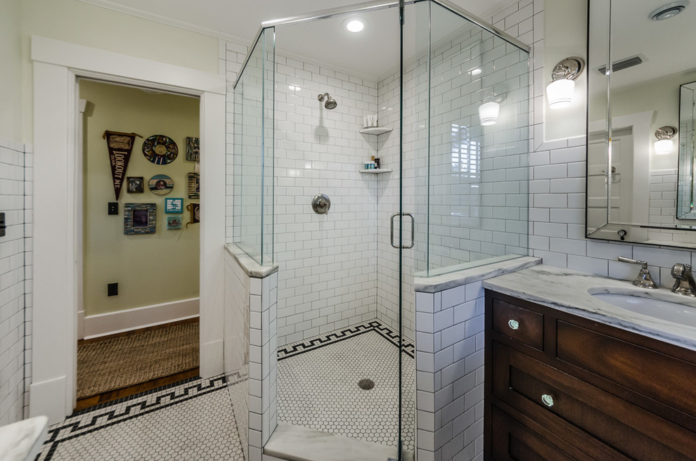 Exemple d'une salle de bain chic en bois foncé avec un placard à porte shaker, une douche d'angle, un carrelage blanc, un carrelage métro, un mur beige, un sol en carrelage de céramique, un lavabo encastré, un sol blanc, une cabine de douche à porte battante et un plan de toilette gris.