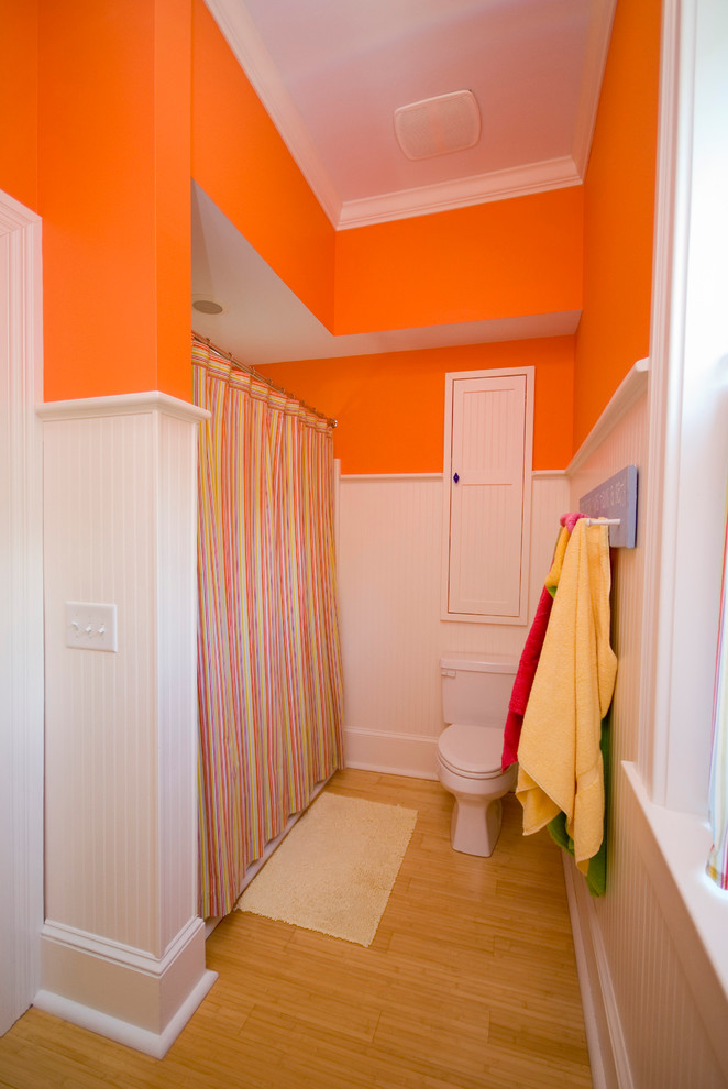 Inspiration för klassiska badrum, med en toalettstol med separat cisternkåpa, orange väggar, ljust trägolv och dusch med duschdraperi