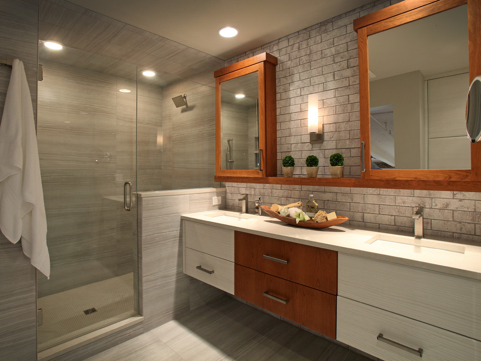 Photo of an industrial shower room bathroom in Atlanta with flat-panel cabinets, medium wood cabinets, a corner shower, grey tiles, a submerged sink and a hinged door.