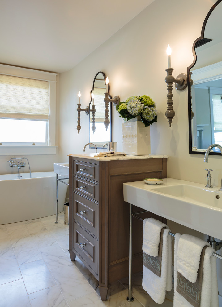 Exemple d'une salle de bain chic en bois foncé avec un placard avec porte à panneau surélevé, une baignoire indépendante, un carrelage blanc, un mur blanc, un sol en marbre, un plan vasque et un plan de toilette en marbre.