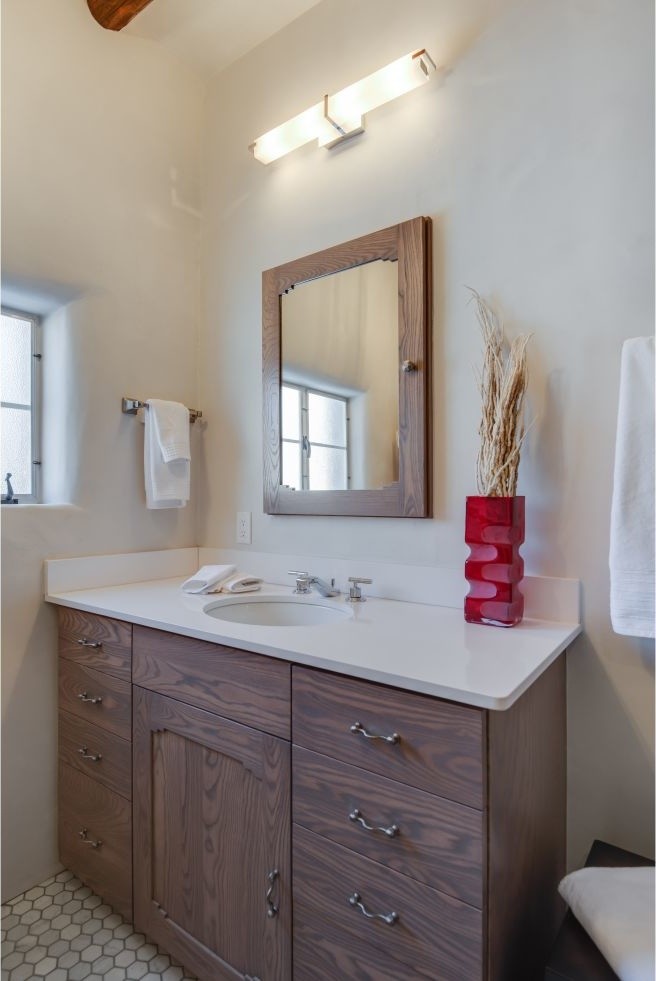 Mid-sized southwest 3/4 white tile and ceramic tile ceramic tile tub/shower combo photo in Albuquerque with an undermount sink, flat-panel cabinets, medium tone wood cabinets, solid surface countertops and white walls