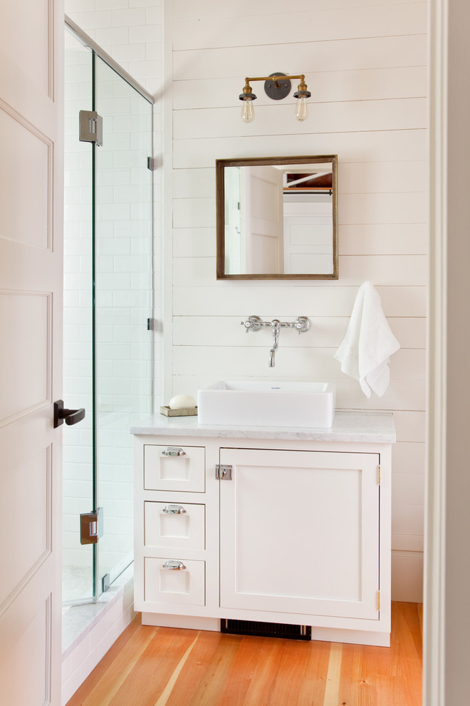 Photo of a classic shower room bathroom in Other with shaker cabinets, white cabinets, white walls, medium hardwood flooring, a vessel sink and brown floors.