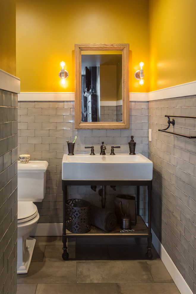 На фото: детская ванная комната среднего размера в стиле неоклассика (современная классика) с открытыми фасадами, искусственно-состаренными фасадами, ванной в нише, душем над ванной, раздельным унитазом, серой плиткой, керамической плиткой, желтыми стенами, бетонным полом, консольной раковиной, столешницей из цинка, серым полом и шторкой для ванной с