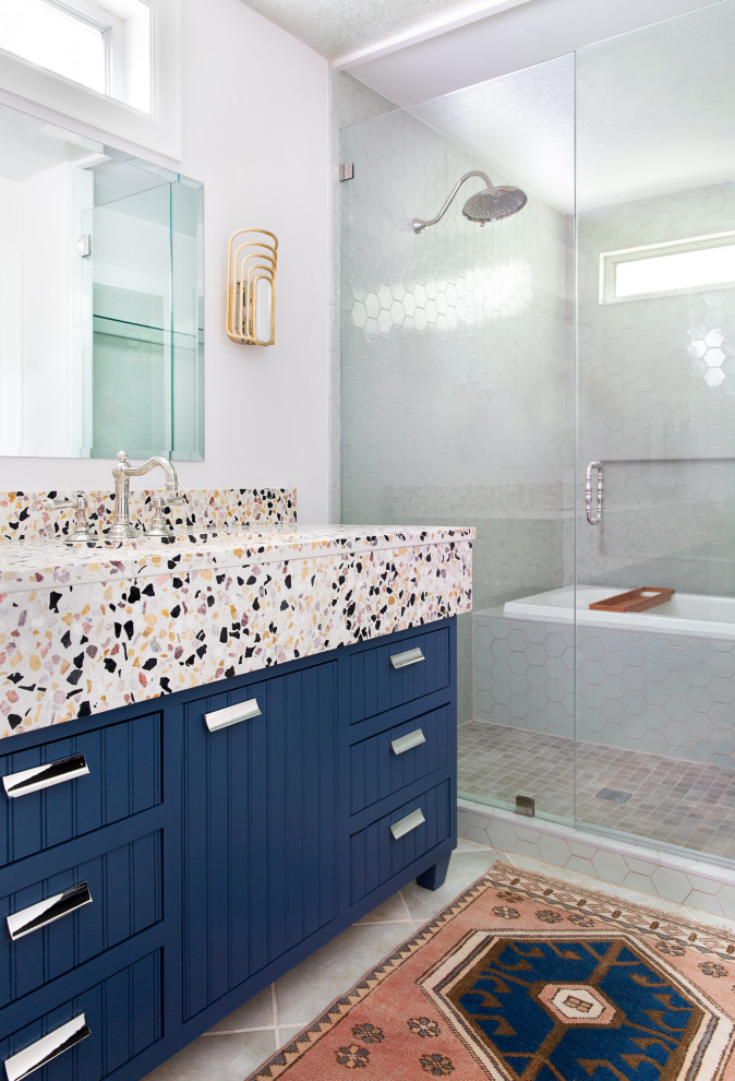 Mittelgroßes Klassisches Badezimmer En Suite mit flächenbündigen Schrankfronten, blauen Schränken, Einbaubadewanne, Nasszelle, weißer Wandfarbe, Unterbauwaschbecken, grauem Boden, bunter Waschtischplatte und freistehendem Waschtisch in Austin