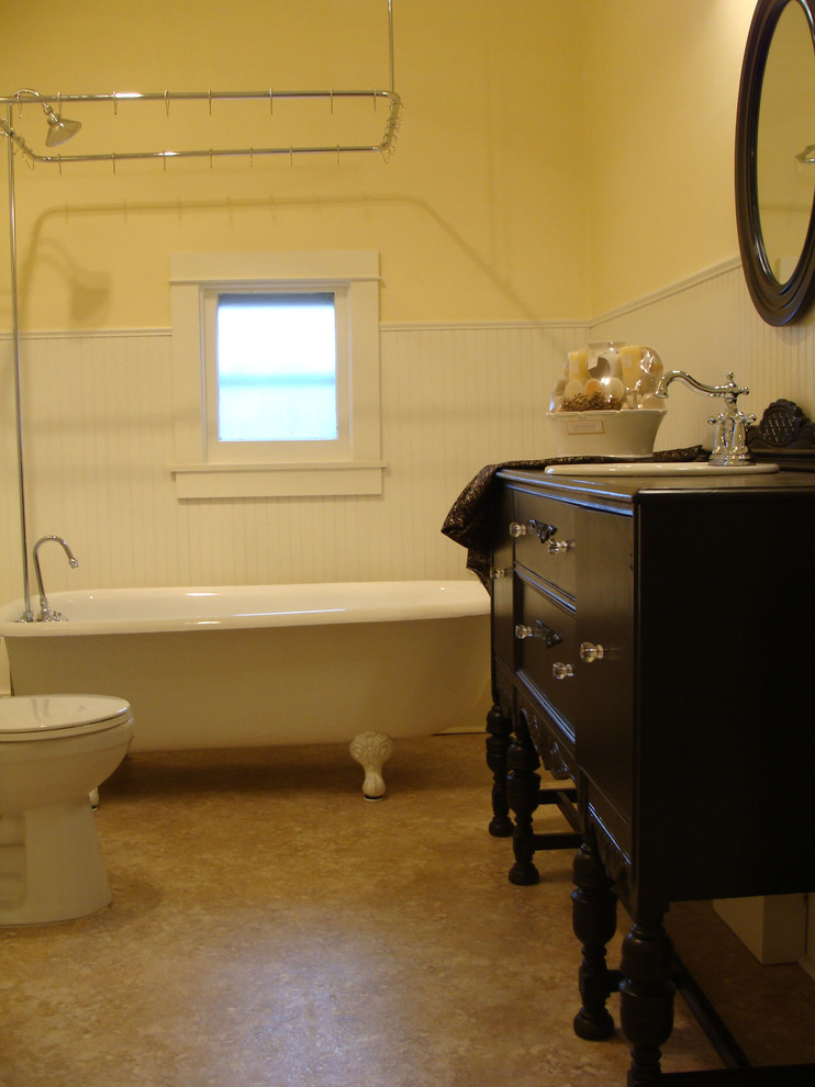 Idées déco pour une salle de bain principale classique en bois foncé de taille moyenne avec un plan de toilette en bois, une baignoire sur pieds, un mur beige et un sol en linoléum.