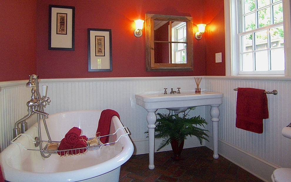 Mittelgroßes Klassisches Badezimmer mit Löwenfuß-Badewanne, roter Wandfarbe, Backsteinboden, Wandwaschbecken und braunem Boden in Raleigh