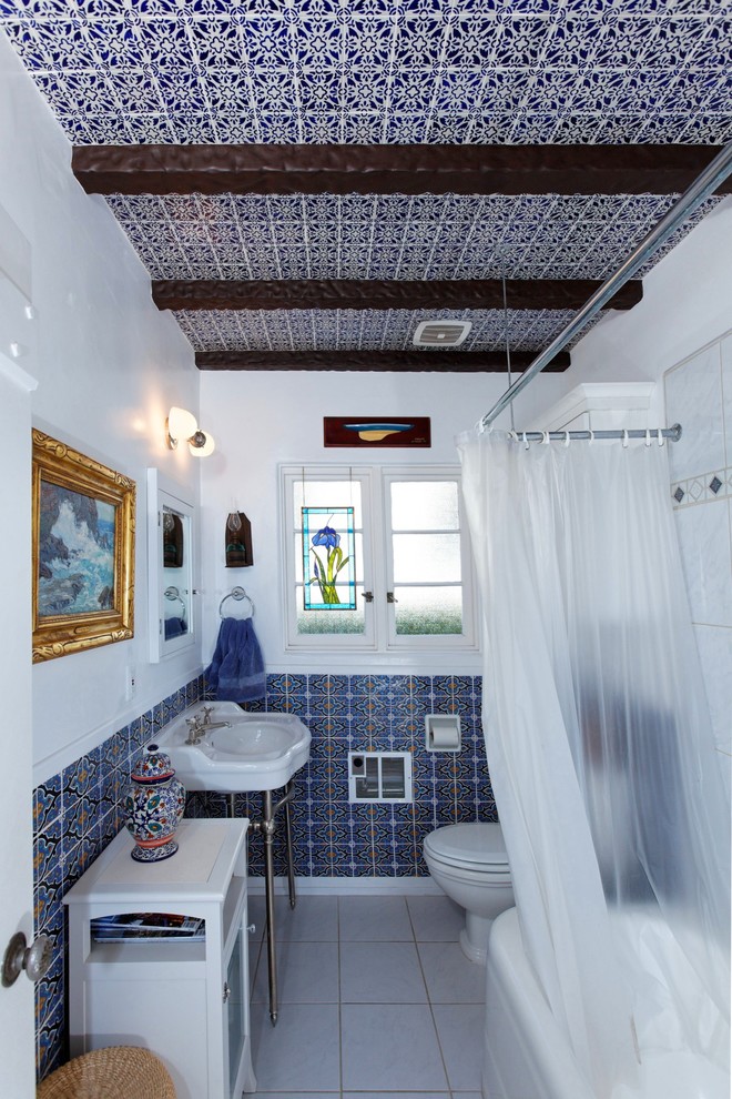 Medelhavsstil inredning av ett badrum, med ett konsol handfat, blå kakel och dusch med duschdraperi