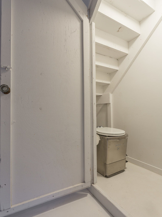 Cette image montre une petite salle de bain nordique avec WC à poser, un mur blanc et un sol en marbre.