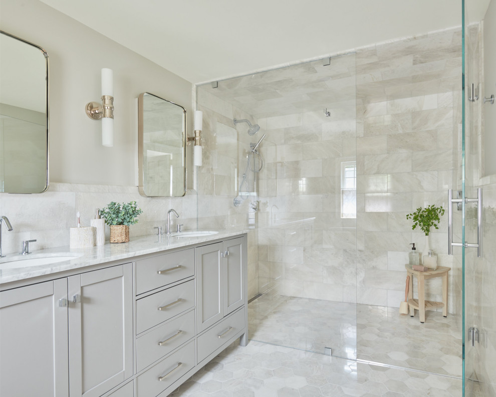 Example of a transitional master gray tile and marble tile marble floor, gray floor and double-sink walk-in shower design in Other with shaker cabinets, gray cabinets, gray walls, marble countertops, a hinged shower door, gray countertops, an undermount sink and a freestanding vanity