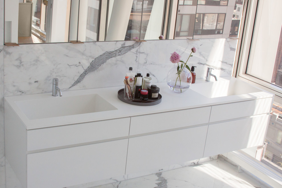 Foto di una stanza da bagno padronale design di medie dimensioni con lavabo integrato, ante lisce, ante bianche, top in superficie solida, piastrelle bianche, piastrelle in pietra e pareti bianche