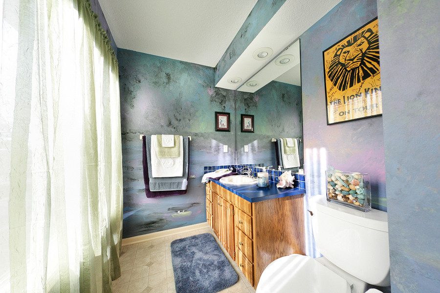 Источник вдохновения для домашнего уюта: большая ванная комната в современном стиле с плоскими фасадами, фасадами цвета дерева среднего тона, синей плиткой, керамической плиткой, разноцветными стенами, полом из керамической плитки, душевой кабиной, накладной раковиной и столешницей из ламината