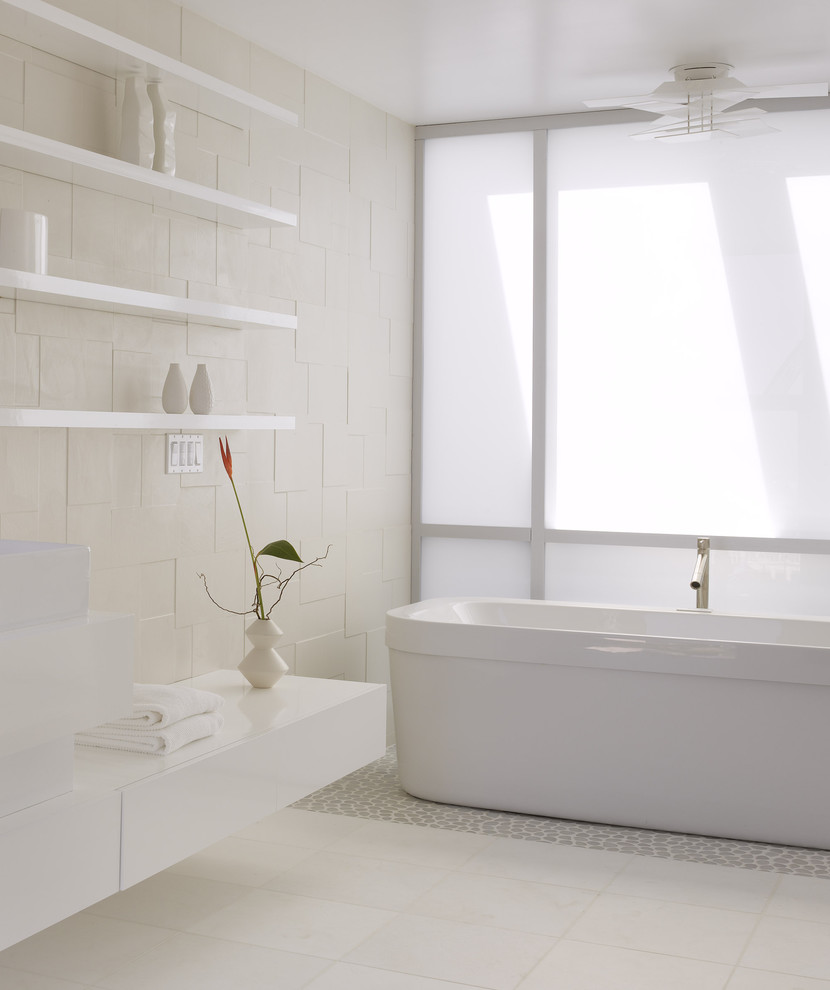 Cette image montre une salle de bain minimaliste avec une baignoire indépendante et un sol en galet.