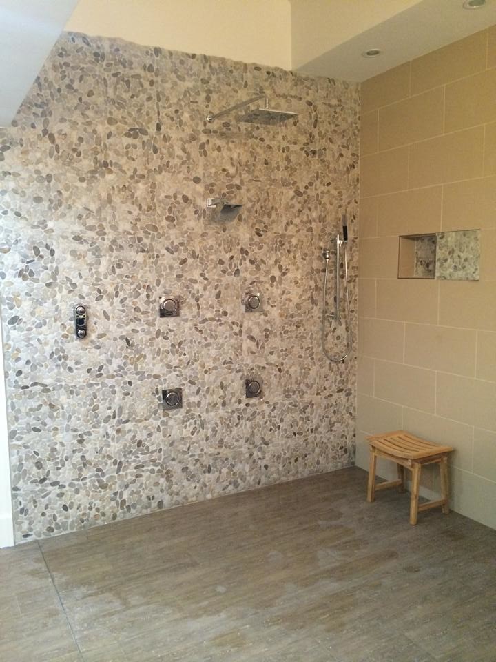 Exemple d'une grande salle de bain principale chic avec une douche ouverte, un carrelage beige, un carrelage de pierre, un mur beige et un sol en carrelage de porcelaine.
