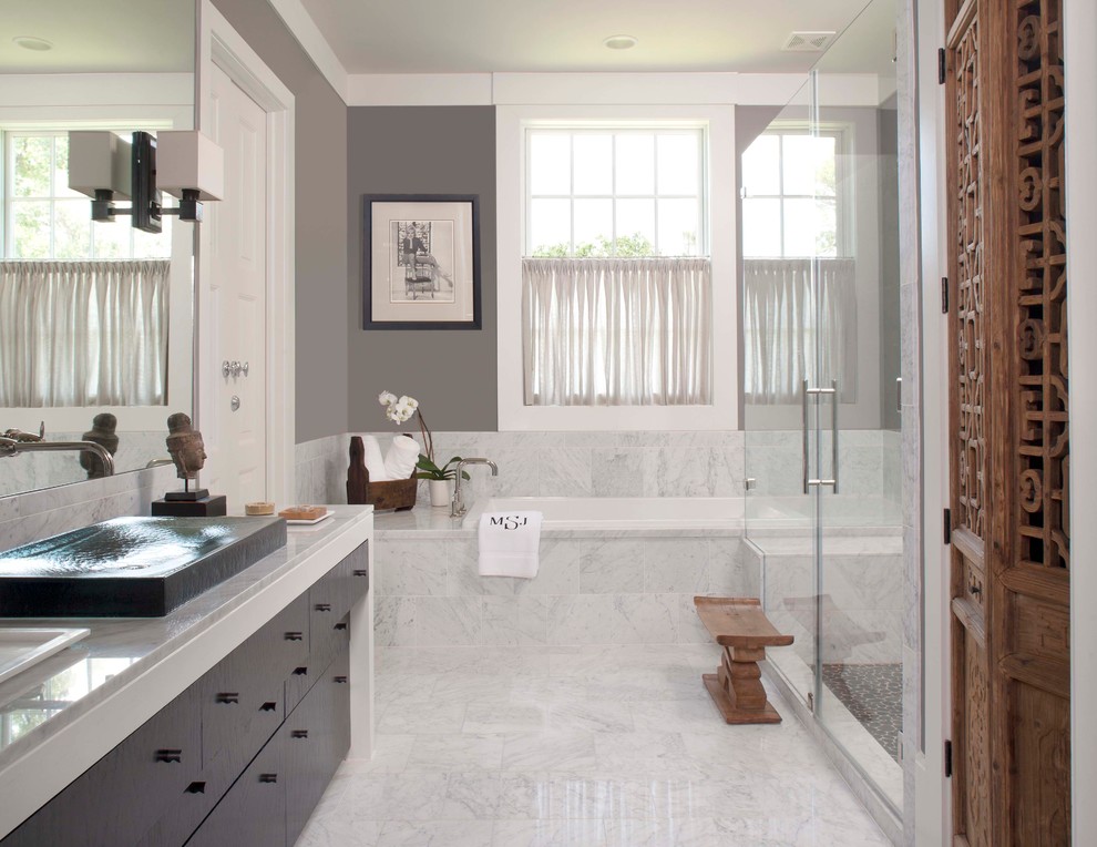 Photo of a large contemporary ensuite bathroom in Houston with flat-panel cabinets, dark wood cabinets, a built-in bath, a corner shower, grey tiles, marble tiles, grey walls, marble flooring, a built-in sink, grey floors and a hinged door.