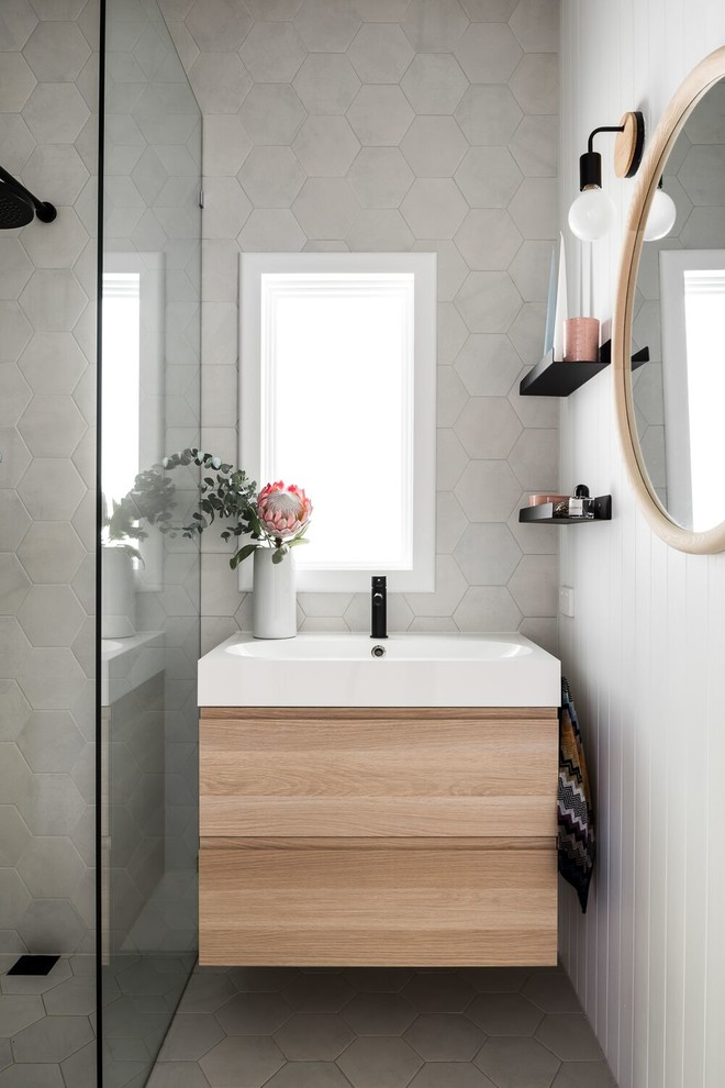 Свежая идея для дизайна: маленькая главная ванная комната в современном стиле с светлыми деревянными фасадами, открытым душем, серой плиткой, керамогранитной плиткой, белыми стенами, полом из керамогранита, подвесной раковиной, столешницей из ламината, серым полом, открытым душем и белой столешницей для на участке и в саду - отличное фото интерьера
