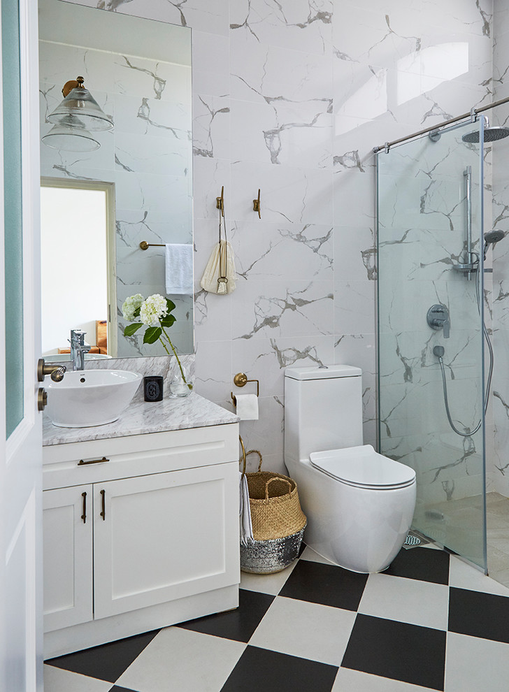 Пример оригинального дизайна: ванная комната в стиле неоклассика (современная классика) с фасадами в стиле шейкер, белыми фасадами, душем в нише, унитазом-моноблоком, белыми стенами, полом из керамогранита, душевой кабиной, настольной раковиной, мраморной столешницей, разноцветным полом и открытым душем