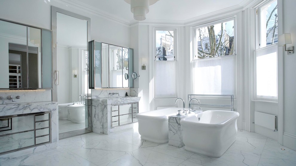 Modern inredning av ett stort en-suite badrum, med ett fristående badkar, vit kakel, marmorkakel, vita väggar, marmorgolv, marmorbänkskiva, vitt golv och släta luckor
