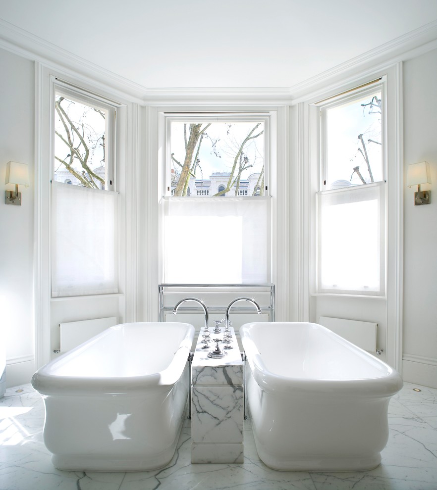 Design ideas for a large contemporary ensuite bathroom in London with freestanding cabinets, white cabinets, a freestanding bath, a built-in shower, a two-piece toilet, white tiles, marble tiles, white walls, marble flooring, a console sink and marble worktops.