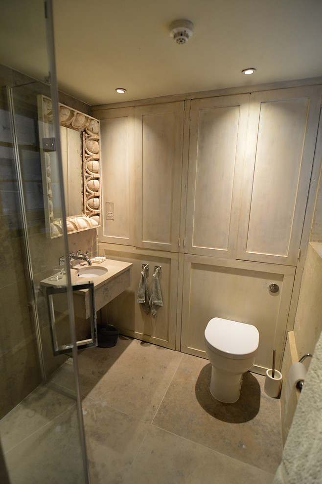 Пример оригинального дизайна: ванная комната в современном стиле с угловым душем, серой плиткой, каменной плиткой, полом из известняка, душевой кабиной, подвесной раковиной и столешницей из известняка
