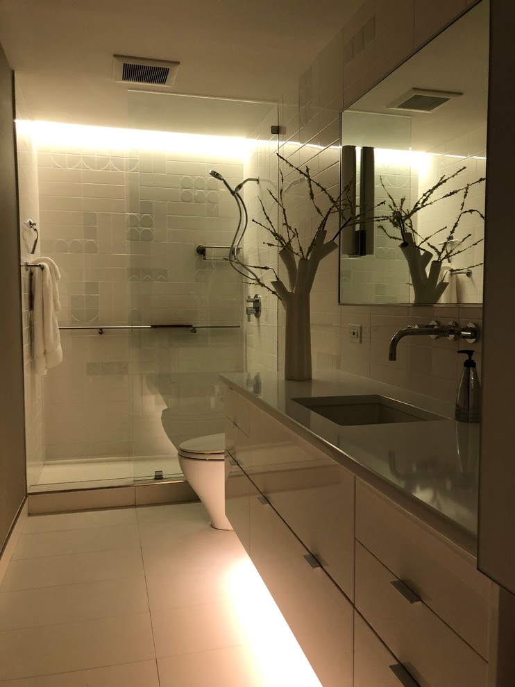 Стильный дизайн: маленькая главная ванная комната в стиле модернизм с стеклянными фасадами, серыми фасадами, открытым душем, унитазом-моноблоком, белой плиткой, керамической плиткой, серыми стенами, полом из керамогранита, врезной раковиной, столешницей из искусственного кварца, белым полом, открытым душем и белой столешницей для на участке и в саду - последний тренд