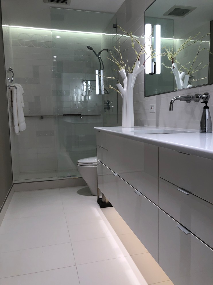 Пример оригинального дизайна: маленькая главная ванная комната в стиле модернизм с стеклянными фасадами, серыми фасадами, открытым душем, унитазом-моноблоком, белой плиткой, керамической плиткой, серыми стенами, полом из керамогранита, врезной раковиной, столешницей из искусственного кварца, белым полом, открытым душем и белой столешницей для на участке и в саду
