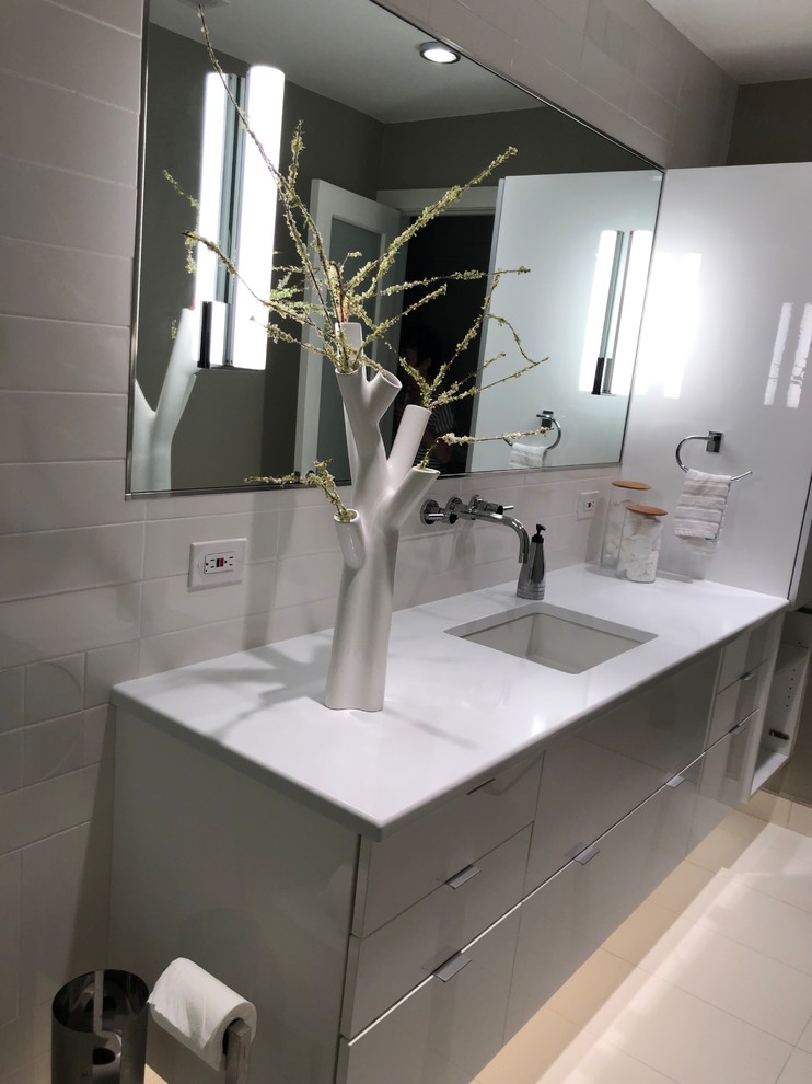 Inspiration for a small modern ensuite bathroom in Dallas with glass-front cabinets, grey cabinets, a walk-in shower, a one-piece toilet, white tiles, ceramic tiles, grey walls, porcelain flooring, a submerged sink, engineered stone worktops, white floors, an open shower and white worktops.