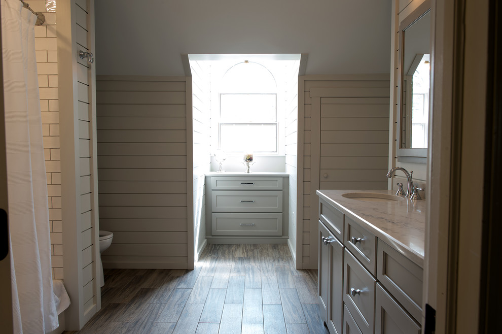 Inspiration for a medium sized traditional family bathroom in Philadelphia with recessed-panel cabinets, grey cabinets, an alcove bath, a shower/bath combination, a two-piece toilet, white walls, porcelain flooring, a submerged sink, engineered stone worktops, brown floors and a shower curtain.