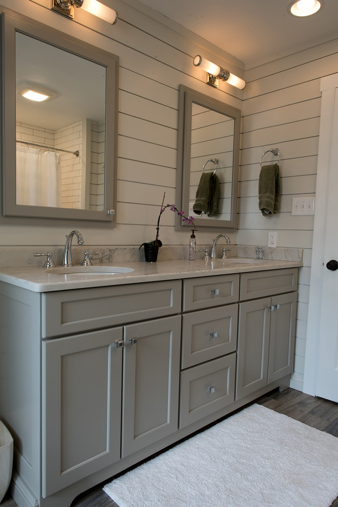 Inspiration for a medium sized classic family bathroom in Philadelphia with recessed-panel cabinets, grey cabinets, an alcove bath, a shower/bath combination, a two-piece toilet, white walls, porcelain flooring, a submerged sink, engineered stone worktops, brown floors and a shower curtain.