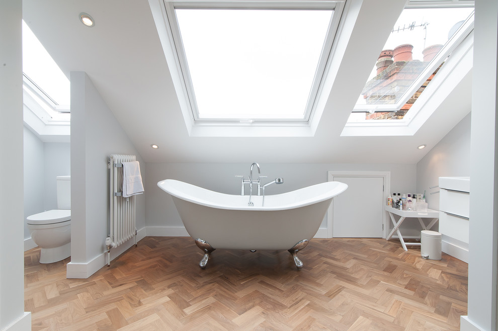 Стильный дизайн: главная ванная комната в современном стиле с ванной на ножках и светлым паркетным полом - последний тренд
