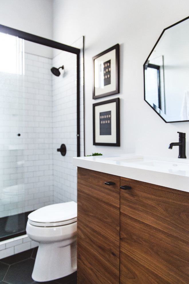 Example of a mid-sized trendy 3/4 white tile and subway tile porcelain tile and black floor bathroom design in San Diego with flat-panel cabinets, light wood cabinets, a two-piece toilet, white walls, an undermount sink, solid surface countertops and white countertops